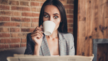 befektető nő újság kávé meglepő getty stock